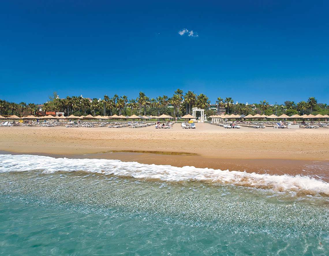 Strand des Defne Star Hotels mit vielen Sonnenliegen und Palmen
