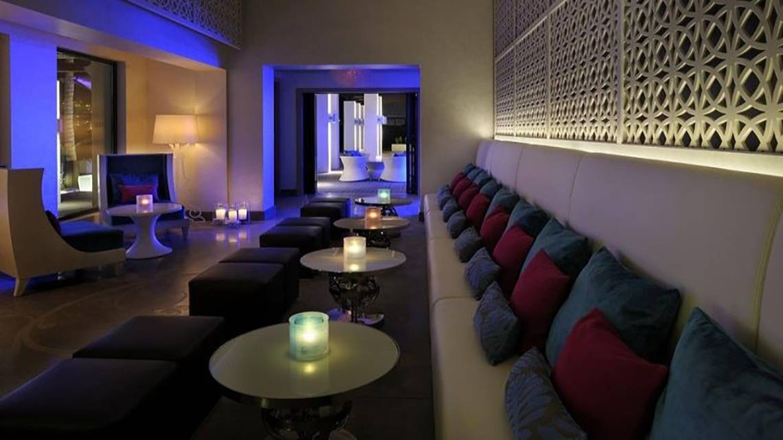 Hotellobby des Palace At One & Only Royal Mirage mit Sofas, Tischen und blauer Beleuchtung.