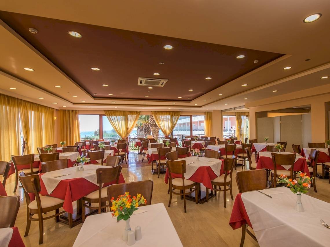 Innenansicht des Restaurants im Astir Beach Hotel in Zakynthos mit vielen gedeckten Tischen und Stühlen.