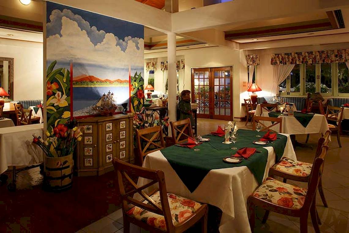 Innenansicht des Restaurants im Cape Panwa Hotel mit grünen und weißen Tischdecken.