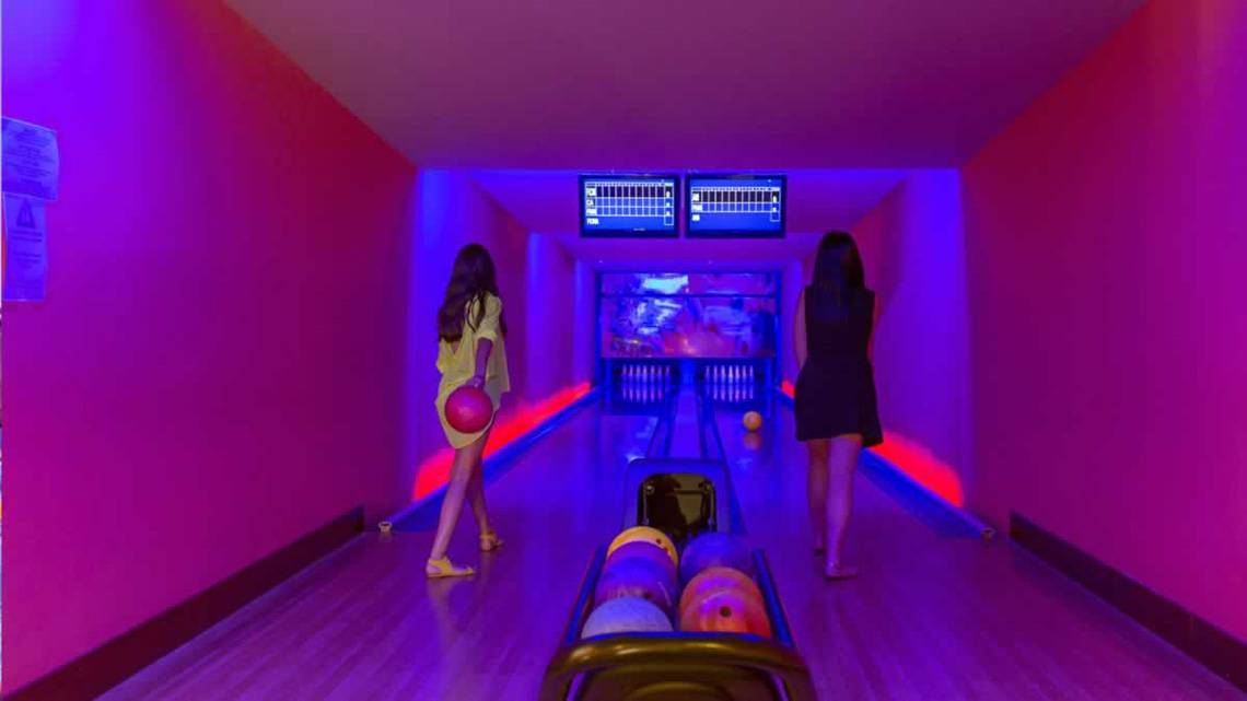 Zwei Frauen spielen Bowling auf der Bowlingbahn des Royal Holiday Palace Hotels.