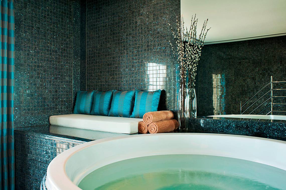 Ein Whirlpool mit blauen Wänden und einer weißen Bank im Westin Dubai Mina Seyahi Beach Resort & Marina.