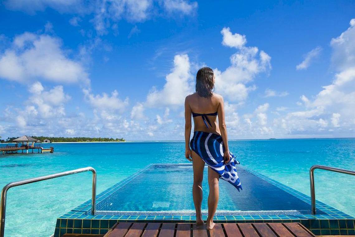 Frau in Badetuch am Pool des Angsana Velavaru mit Blick auf das Meer