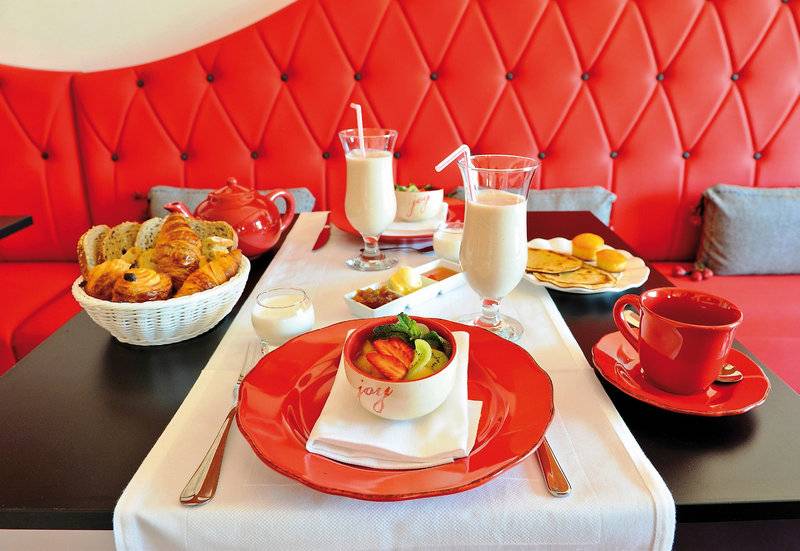 Frühstückstisch im Boutique Hotel Liberata mit Croissants, Joghurt, und Getränken.