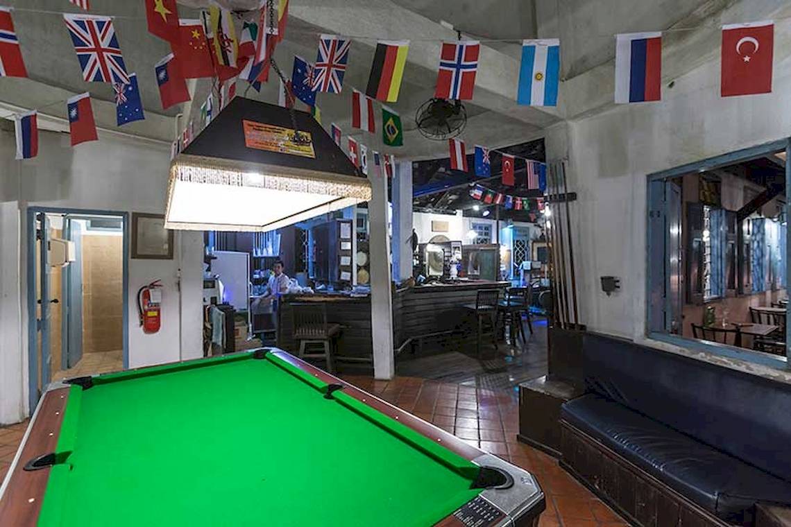 Pooltisch im Cape Panwa Hotel mit bunten Flaggen an der Decke.