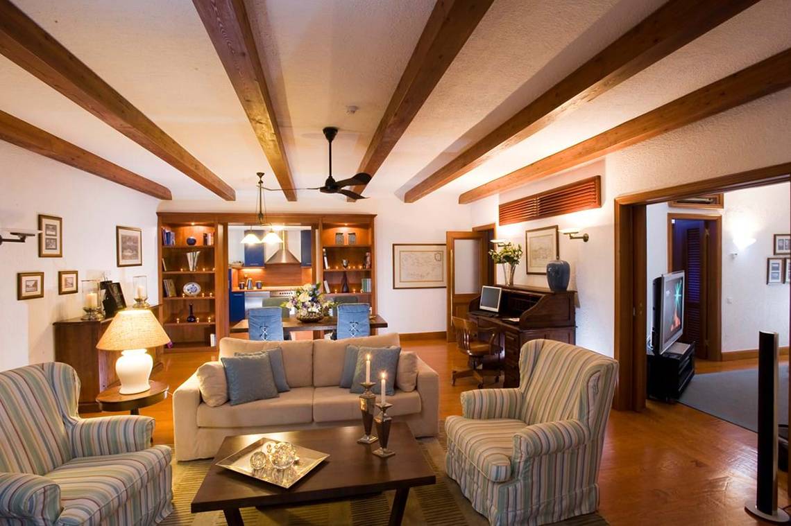 Das Wohnzimmer des Elounda Bay Palace mit Möbeln, einem Kamin und einem Fernseher.