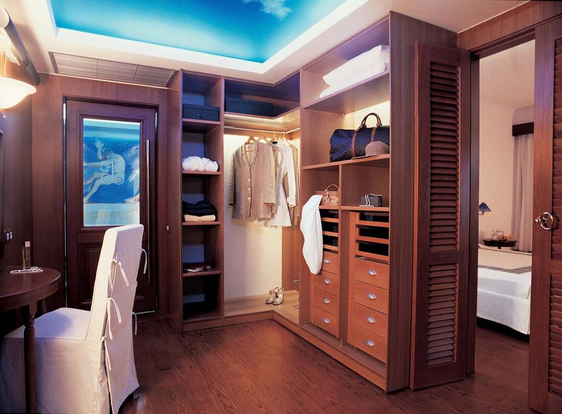 Kleiderschrank in einem Zimmer des Elounda Bay Palace Hotels mit vielen Regalen und Schubladen.