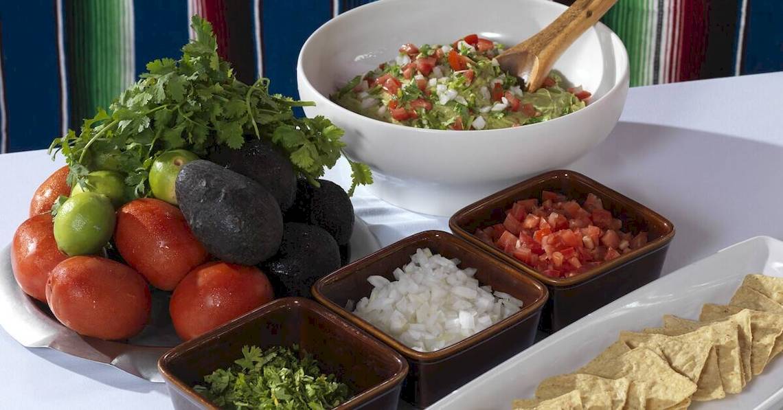 Buffet-Auswahl im Paradisus Playa del Carmen mit Guacamole, Tomaten, Avocados, Zwiebeln, Limetten und Tortilla-Chips.