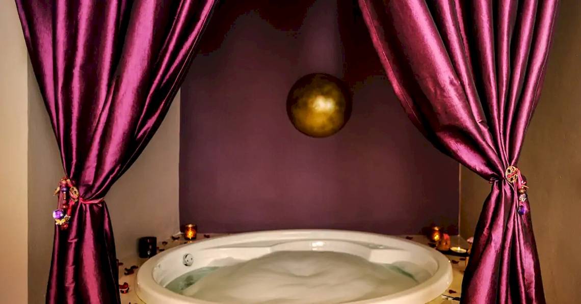 Whirlpool im Hotel Paradisus Playa del Carmen, umgeben von roten Vorhängen und einer goldenen Kugel.