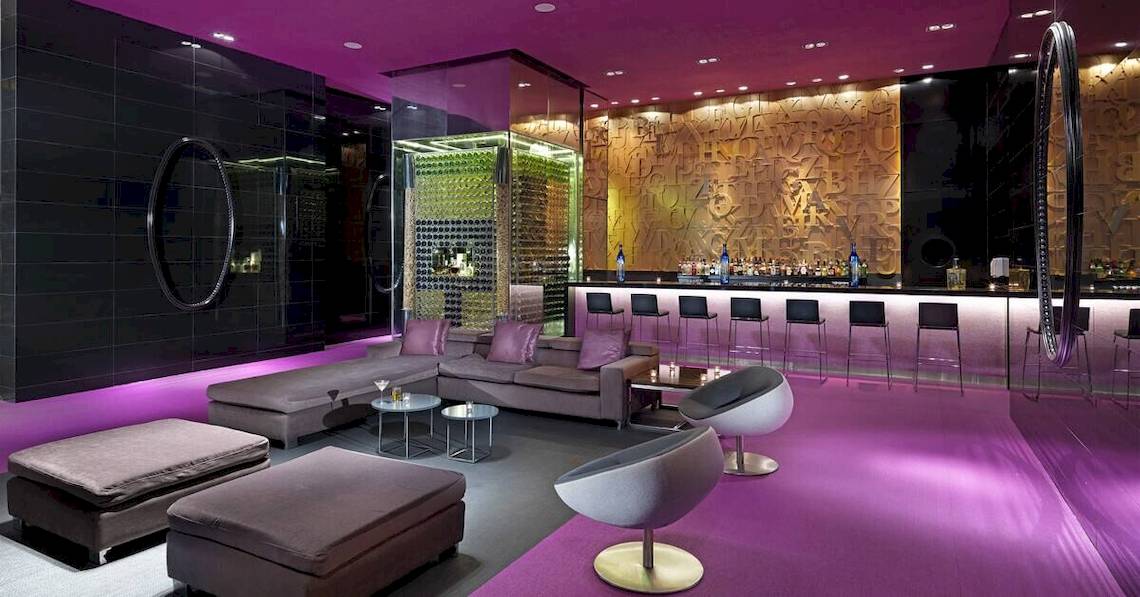 Innenbereich des Paradisus Playa del Carmen Hotels mit violettem Dekor und einer Bar.