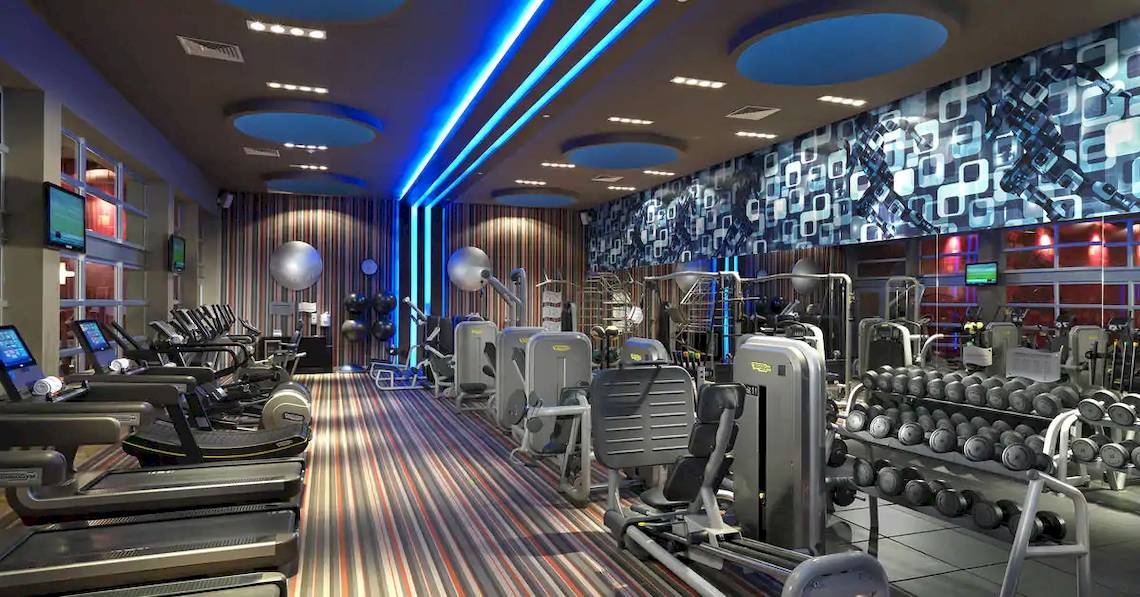 Fitnesscenter im Paradisus Playa del Carmen Hotel mit modernen Geräten und blauer Beleuchtung