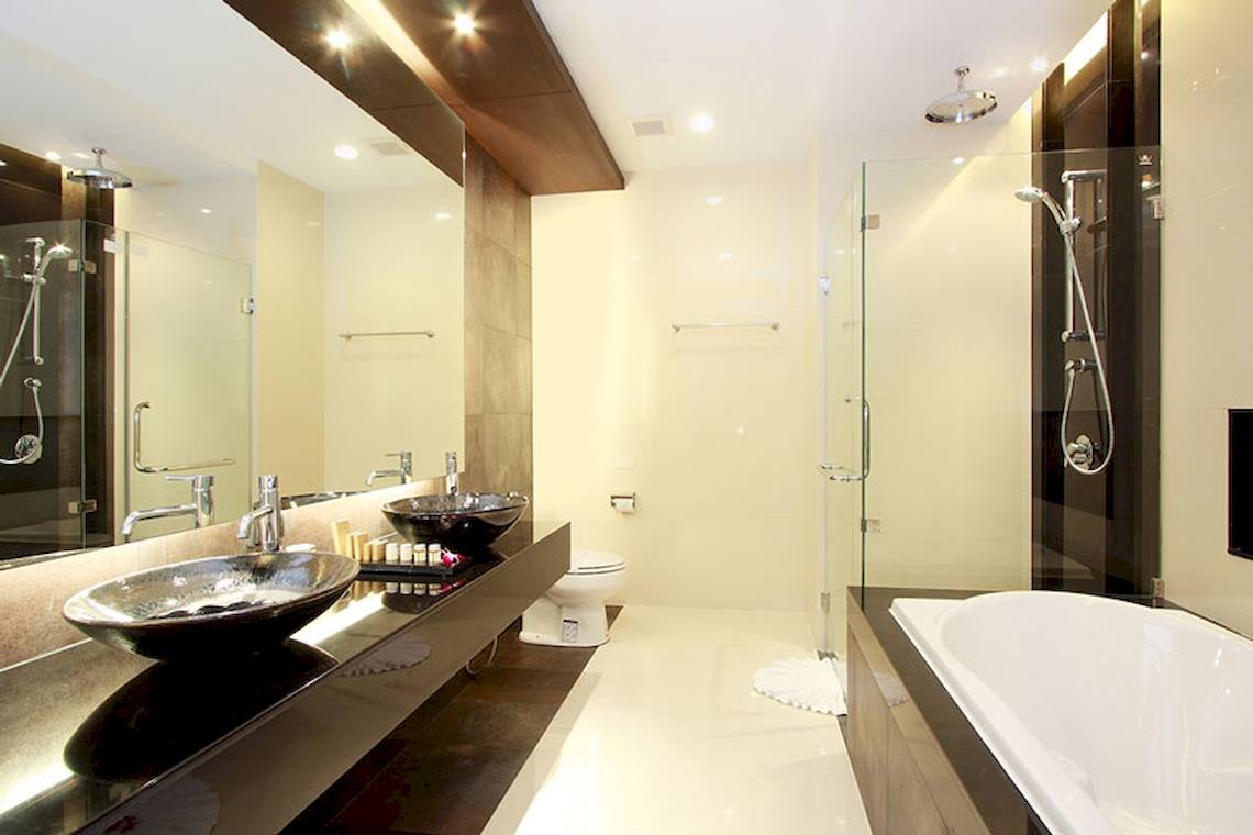 Ein modernes Badezimmer im Cape Panwa Hotel mit zwei Waschbecken, einer Toilette und einer Dusche.