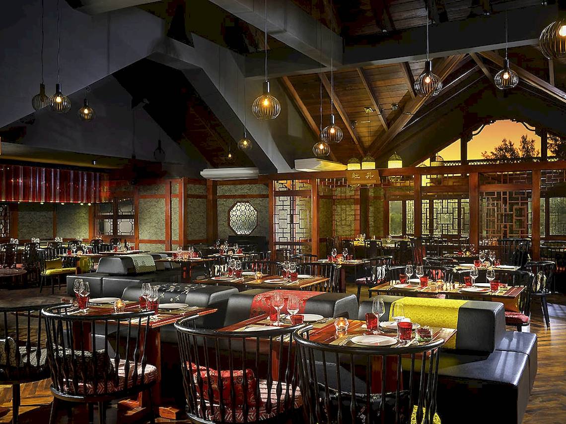Innenansicht des Restaurants im Sofitel Mauritius L'Imperial Resort & Spa mit Tischen, Stühlen und Tischdecken.