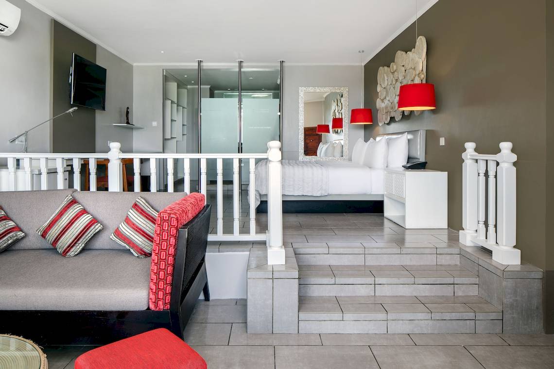 Innenansicht des Schlafzimmers im Fisherman's Cove Resort mit Bett, Fernseher und Wohnzimmer.
