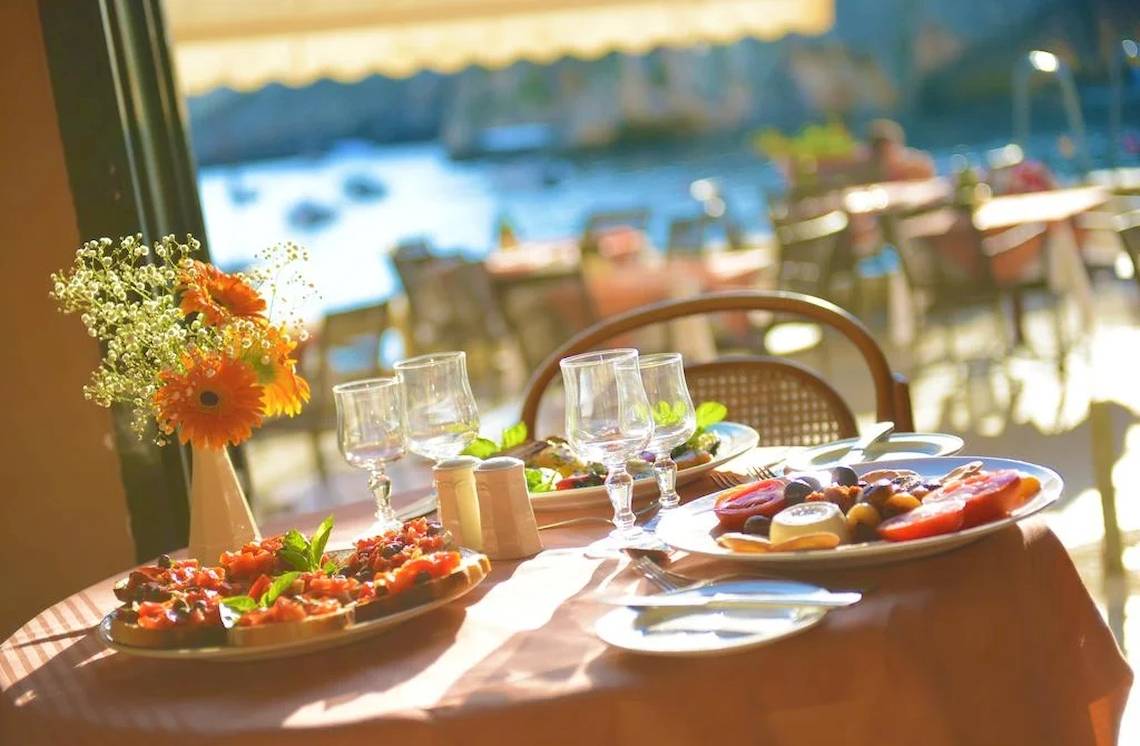 Terrassentisch im Saint Patrick's Hotel Gozo mit verschiedenen Speisen und Getränken.