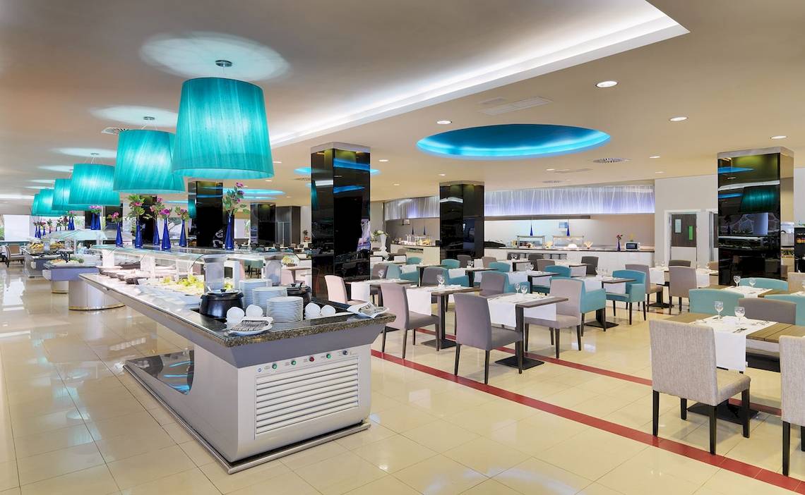 Buffetbereich im H10 Playa Meloneras Palace Hotel mit blauen Leuchten und modernen Möbeln.