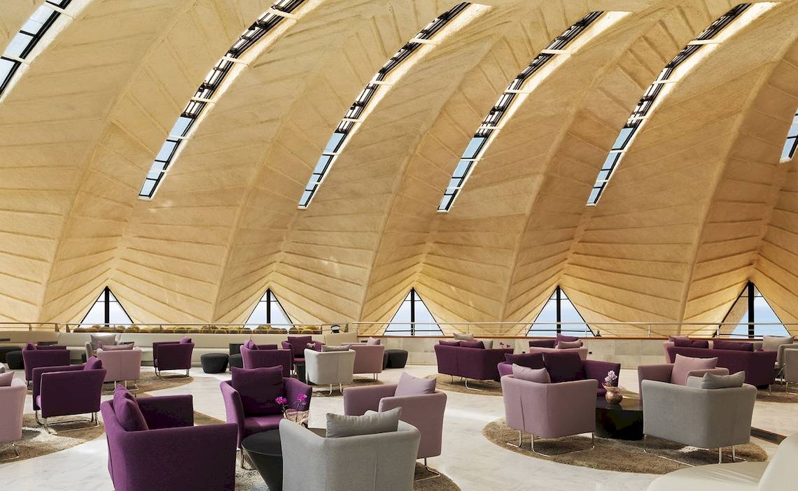 Loungebereich im H10 Playa Meloneras Palace mit vielen weichen Möbeln und großen Fenstern.