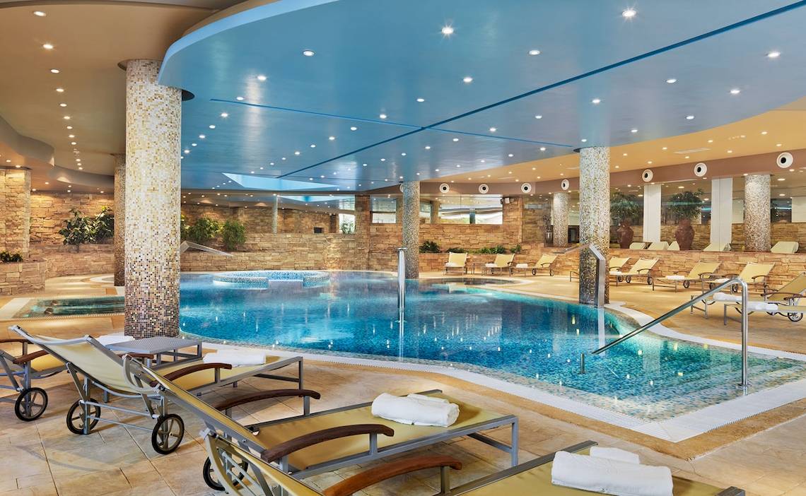 Innenpool des H10 Playa Meloneras Palace mit Lounge-Stühlen und einer blauen Decke.