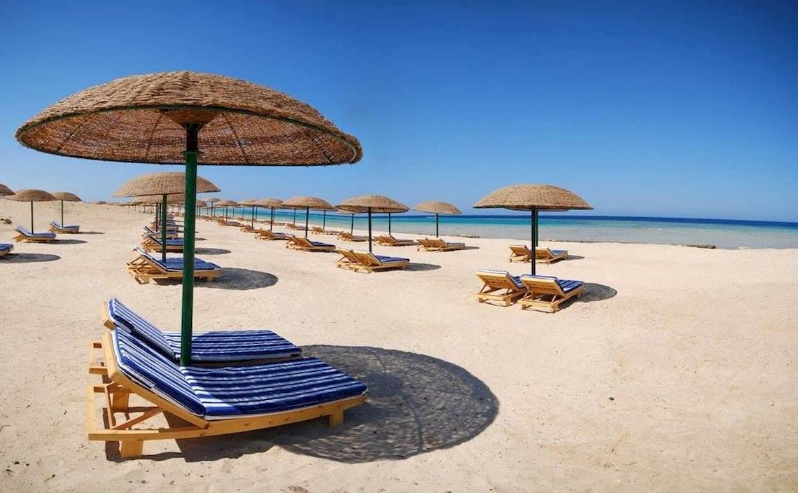 Strand mit Sonnenliegen und Sonnenhuten im Gorgonia Beach Resort