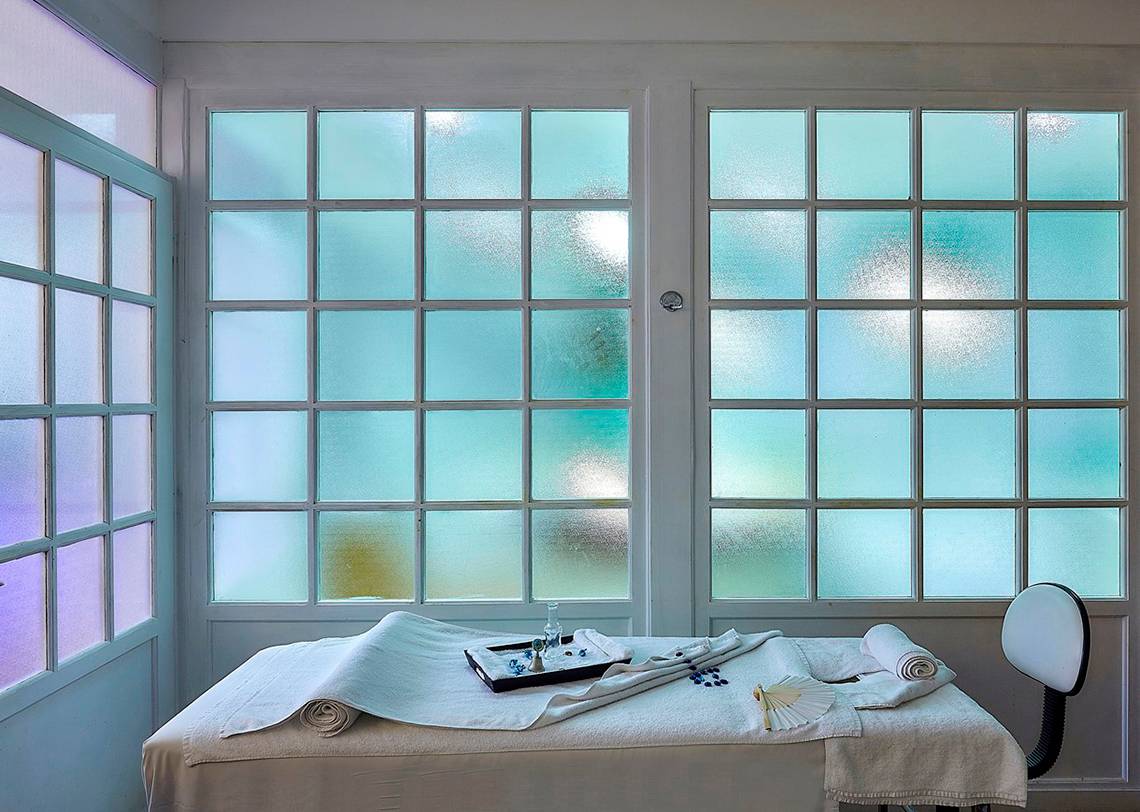 Behandlungsraum mit Fenstern und Tisch im Alexander Beach Hotel & Village Resort
