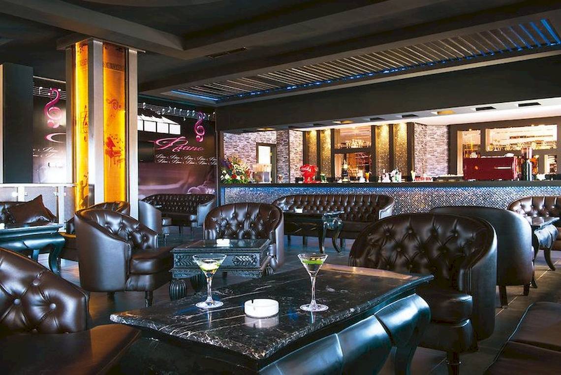 Pickalbatros Aqua Fun Club Lounge mit schwarzen Ledersesseln und einer Theke.