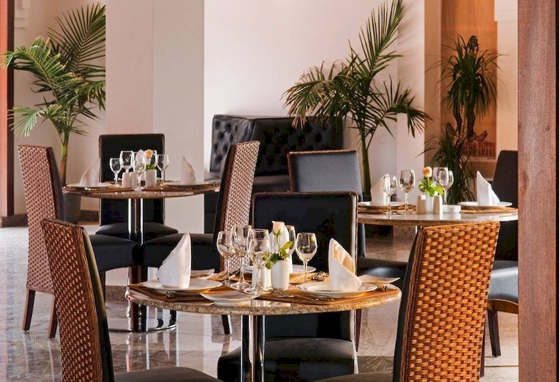 Restaurant des Pickalbatros Aqua Fun Club Hotels mit gedeckten Tischen und Pflanzen im Hintergrund.