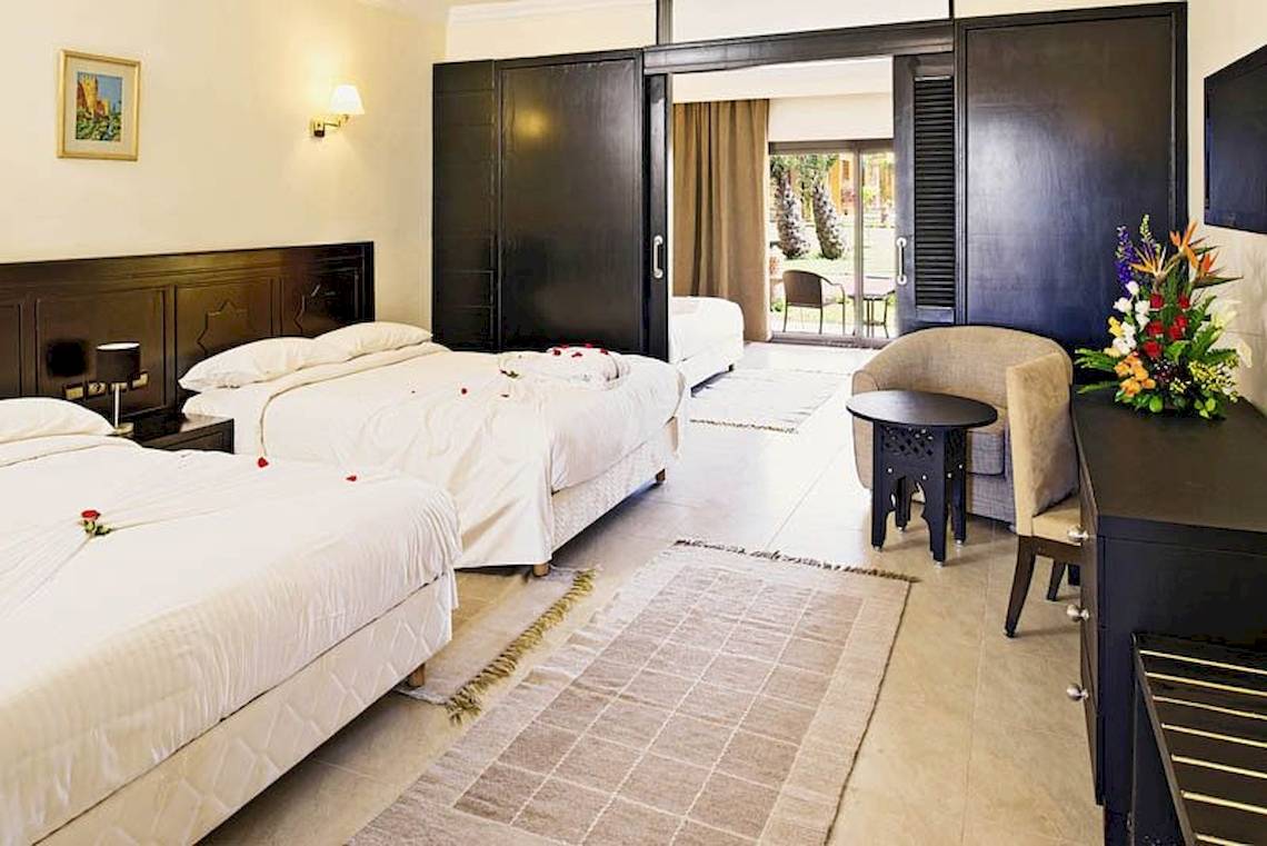 Drei Doppelbettzimmer mit weißen Laken, Kissen und Blumendekoration im Pickalbatros Aqua Fun Club Hotel.