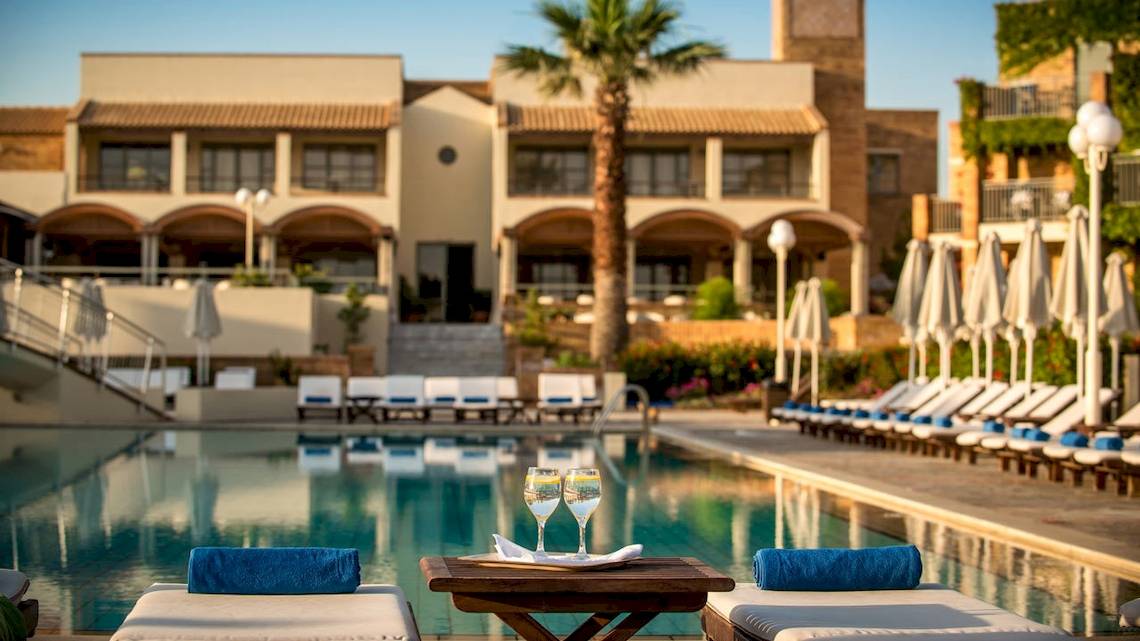 Der Poolbereich des Bella Beach Hotels mit Getränken und Sonnenliegen.