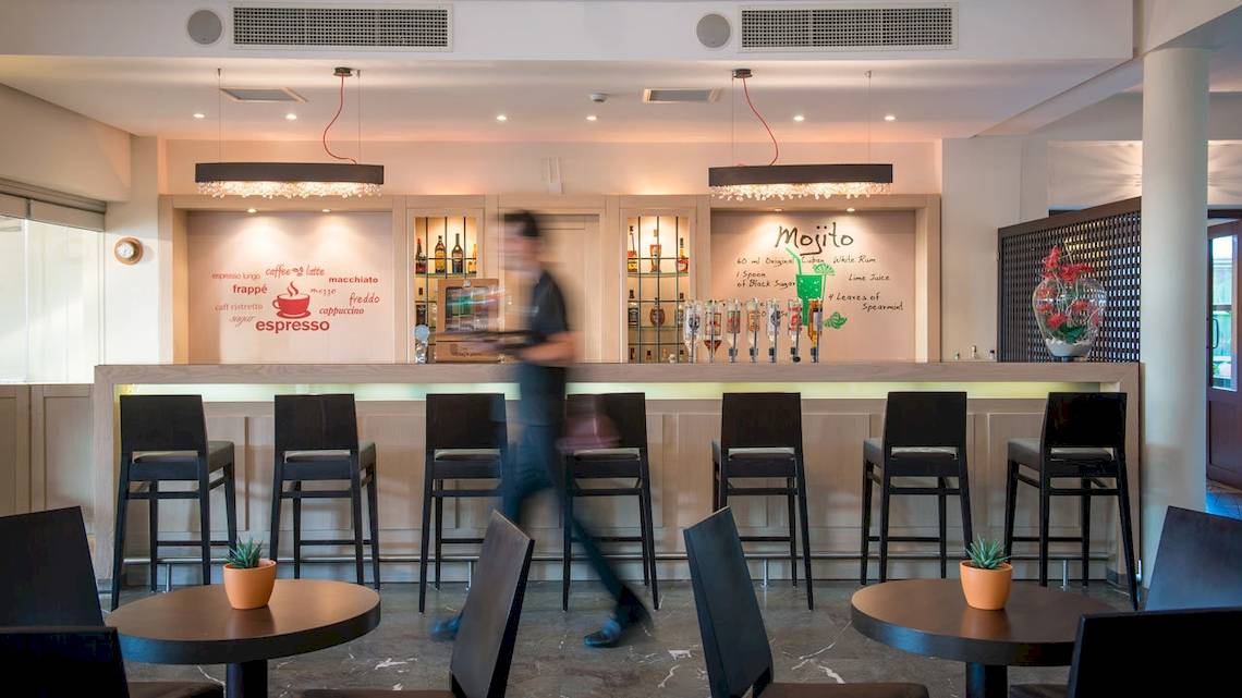 Barbereich im Bella Beach Hotel mit Barhockern und Dekor