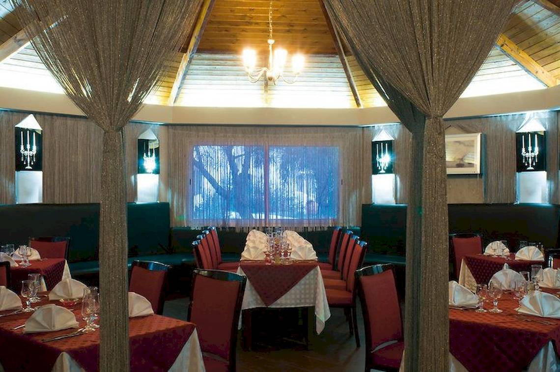 Innenbereich eines Restaurants im Fiesta Beach Djerba Hotel mit Tisch und Stühlen.