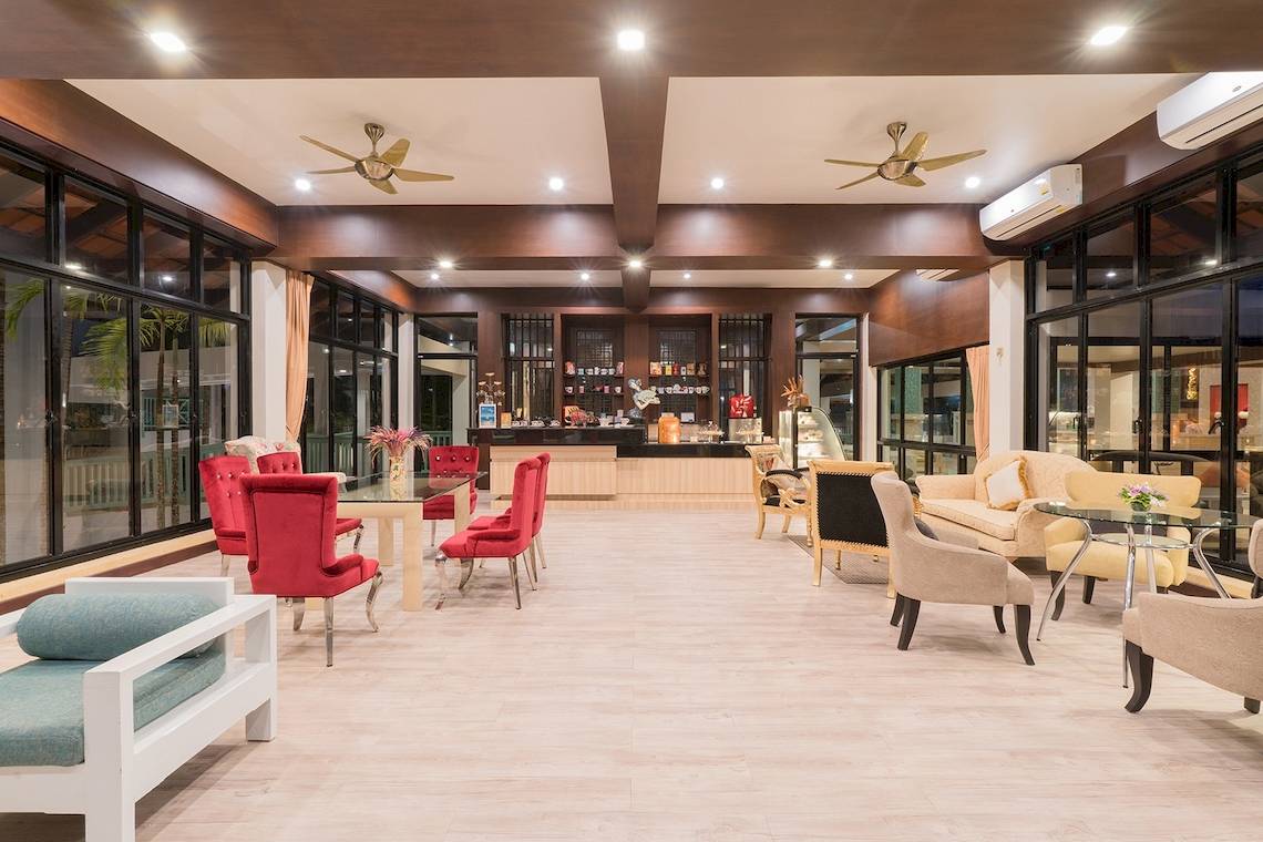 Lobby-Bereich des Briza Beach Resorts mit Tischen, Stühlen und Möbeln.