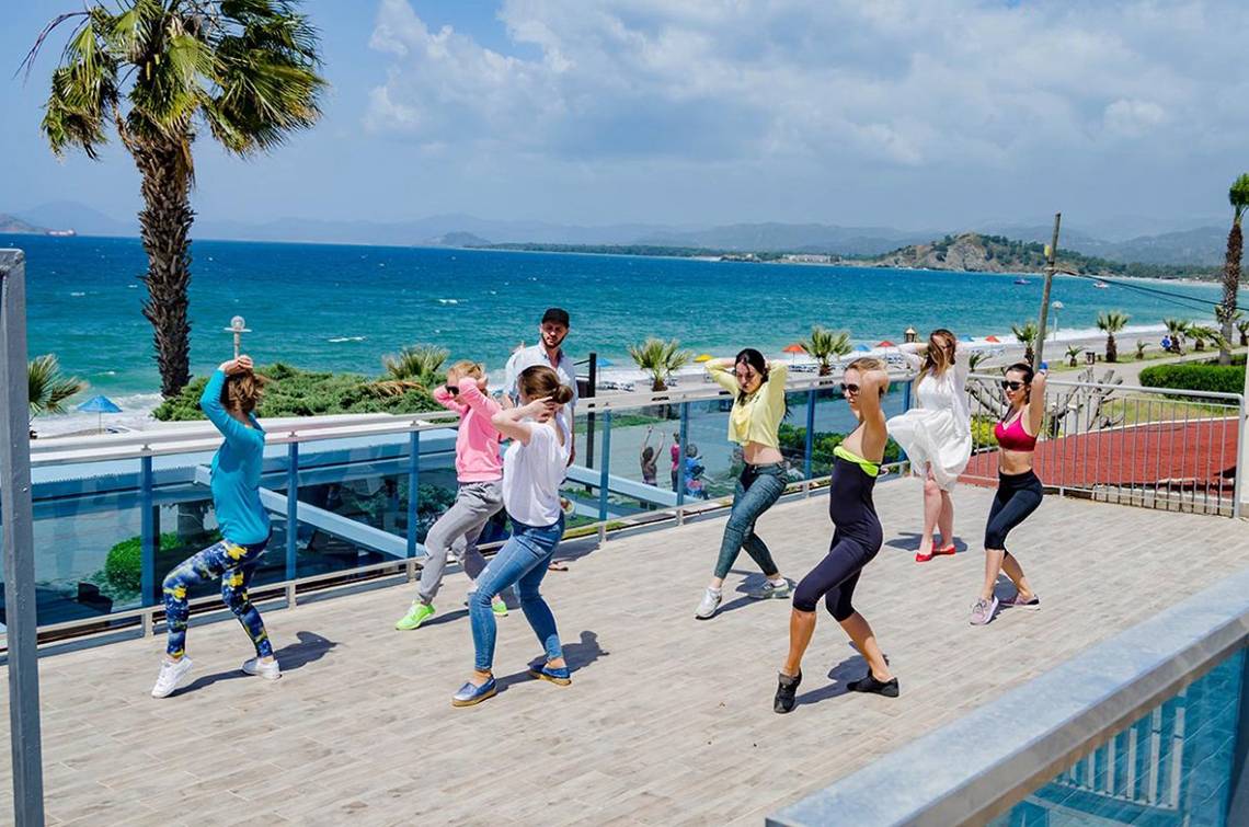 Gruppe von Frauen und Männern, die Aerobic auf der Dachterrasse des Malhun Hotels machen