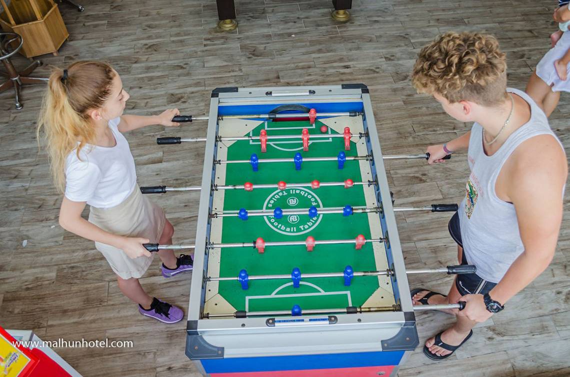 Ein Paar spielt Tischfussball im Malhun Hotel.