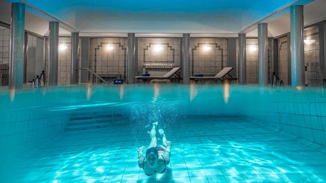 Eine Frau schwimmt im Innenpool des Bella Beach Hotels.
