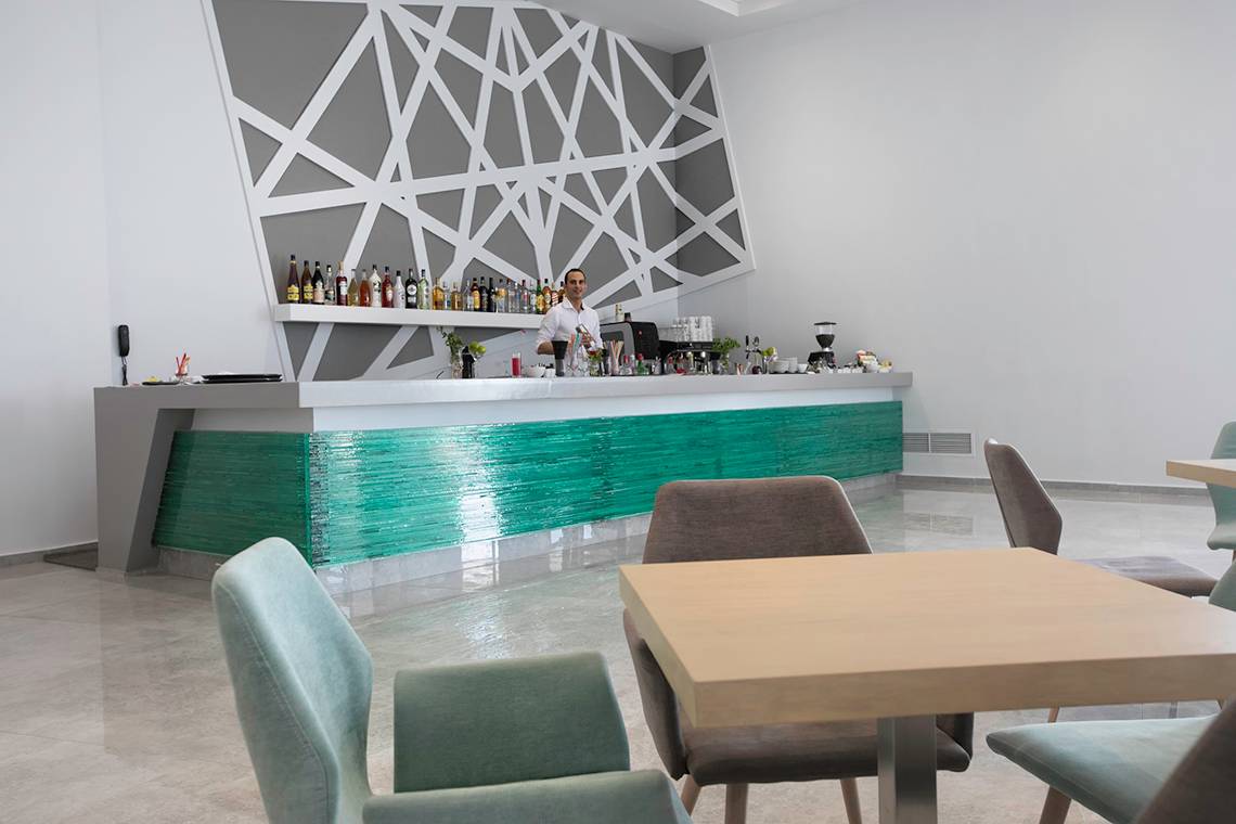 Barbereich des Akti Imperial Deluxe Resorts mit grüner Theke und geometrischen Wandverzierungen