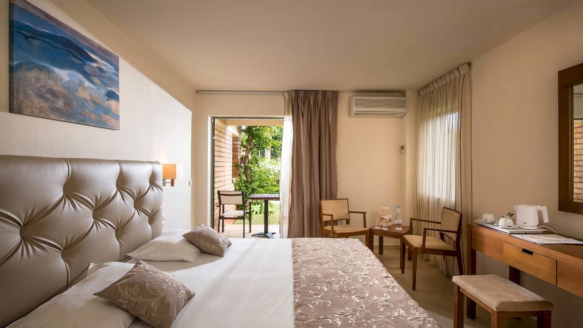 Bella Beach Hotel Zimmer mit zwei Betten und Balkonzugang.