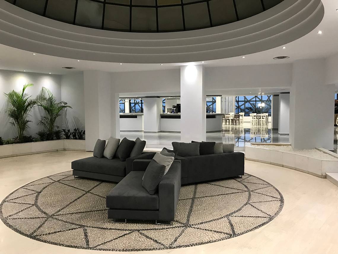 Loungebereich im Akti Imperial Deluxe Resort & Spa Hotel mit modernen Möbeln und geometrischem Teppich.