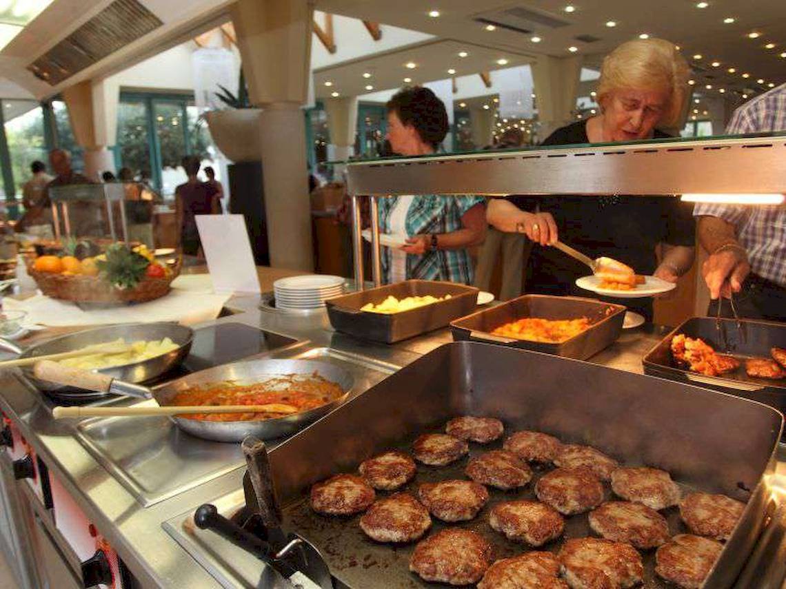 Personen, die in einem Buffetbereich des Bretanide Sport & Wellness Resorts essen.