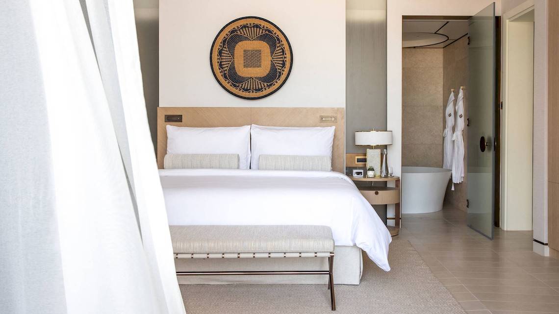 Hotelzimmer im Jumeirah at Saadiyat Island Resort mit Bett, Tisch, Lampe und Badezimmer