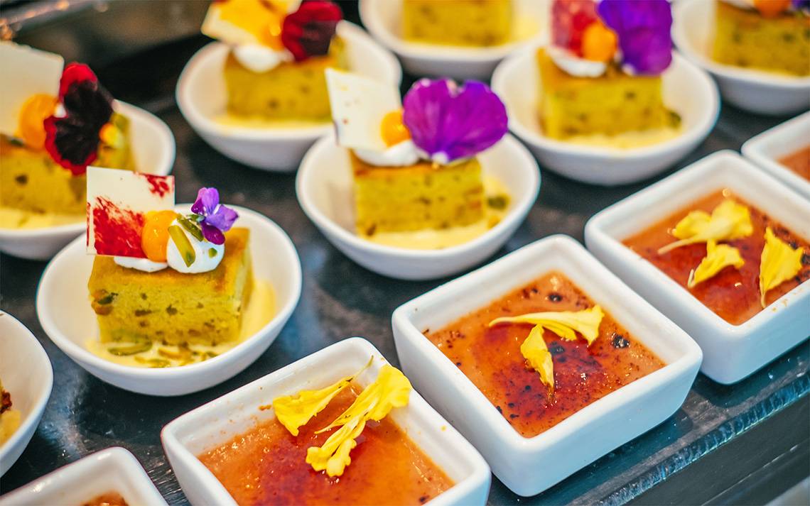 Mehrere Desserts in kleinen weißen Schalen auf einem Tablett im Finolhu Baa Atoll Hotel auf den Malediven.