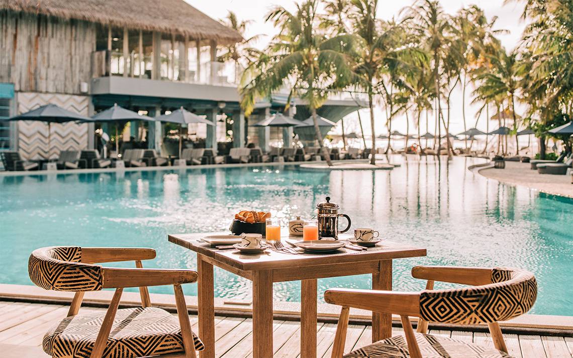 Frühstückstisch am Pool des Finolhu Baa Atoll Hotels auf den Malediven