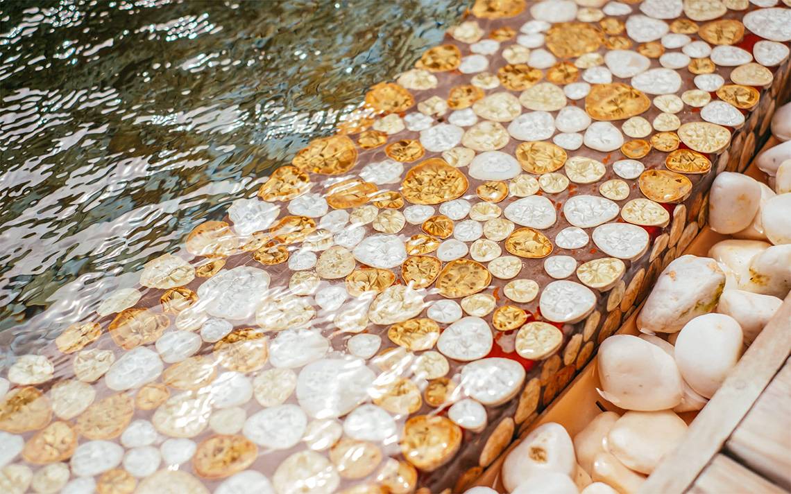 Gold- und weiße Steine am Rand eines Wasserbeckens des Finolhu Baa Atoll Maldives Hotels
