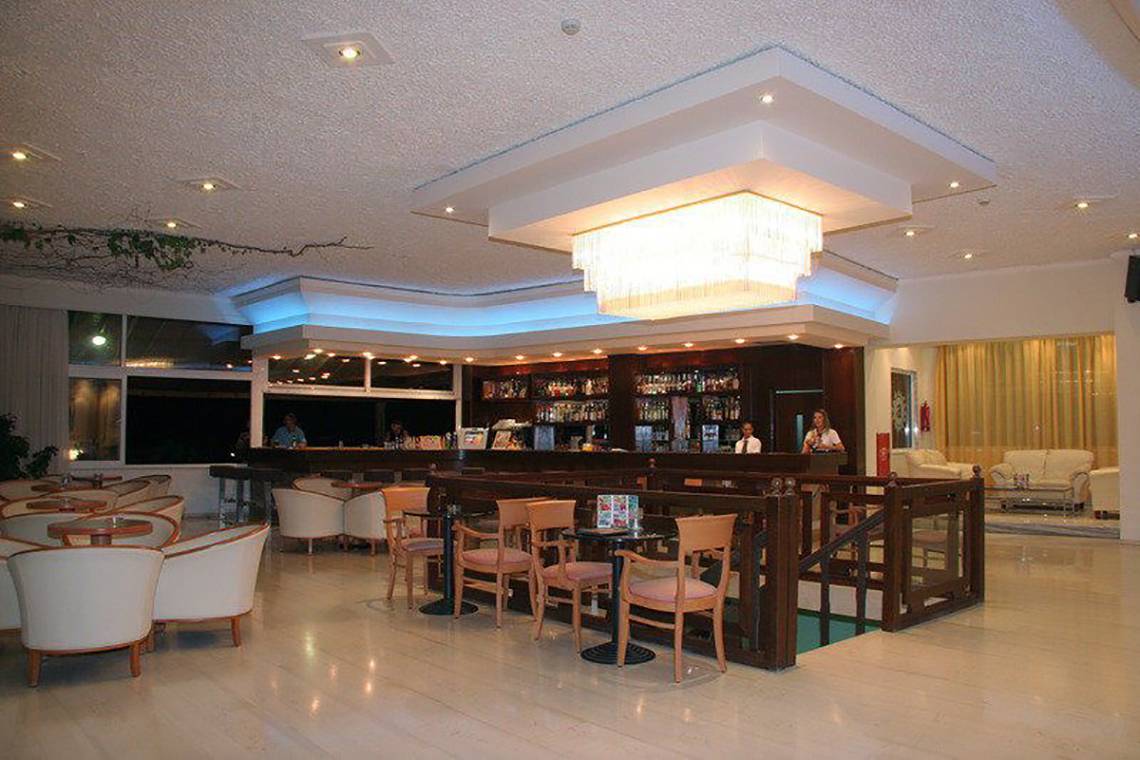 Die Bar im Atlantis Beach Hotel auf Kos mit vielen Tischen und Stühlen.