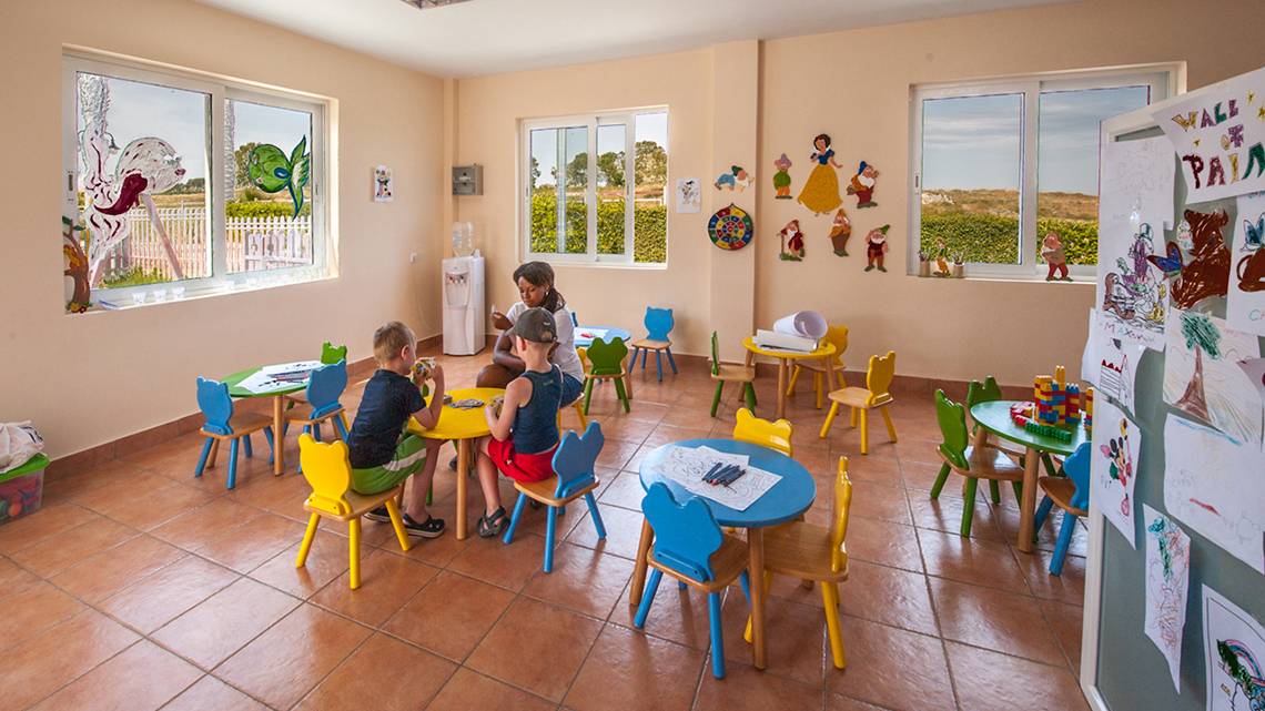 Innenansicht des Horizon Beach Resorts mit Kindern, die am Tisch spielen.