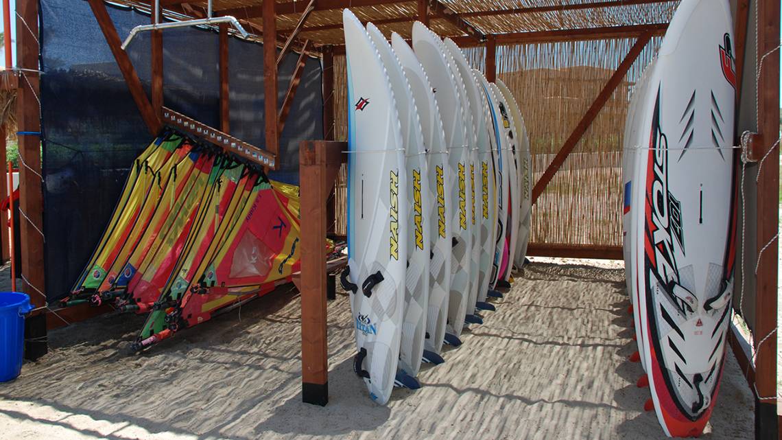 Mehrere Surfbretter, die im Schattenbereich des Horizon Beach Resorts aufbewahrt werden.