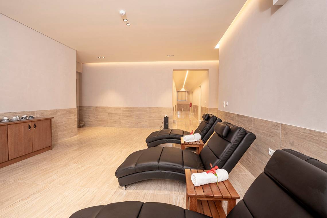Loungebereich im Horizon Beach Resort mit schwarzen Ledersofas und Holztischen.