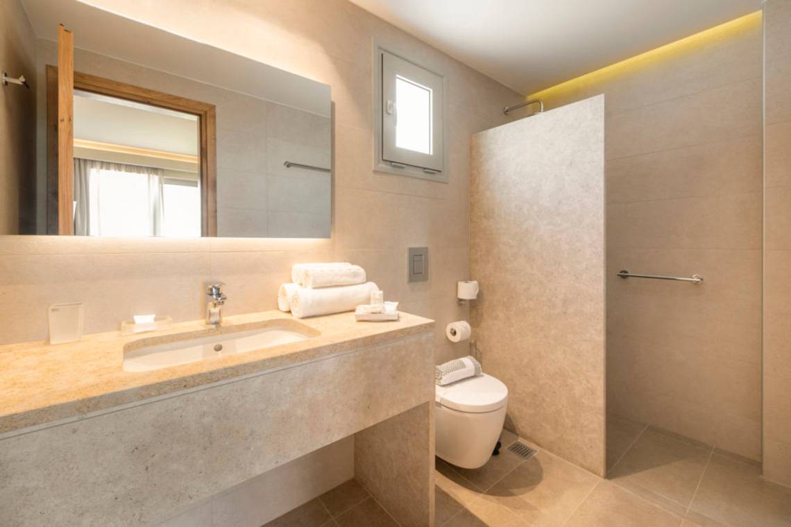 Ein Badezimmer im Horizon Beach Resort mit einer Dusche, Toilette, Waschbecken und Spiegel.
