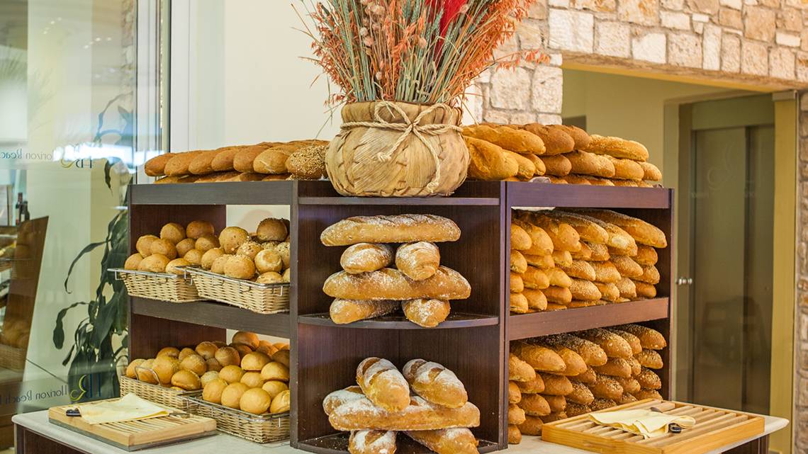 Blick auf das Brotangebot im Horizon Beach Resort mit verschiedenen Brötchen und Brotsorten auf Holzregalen.