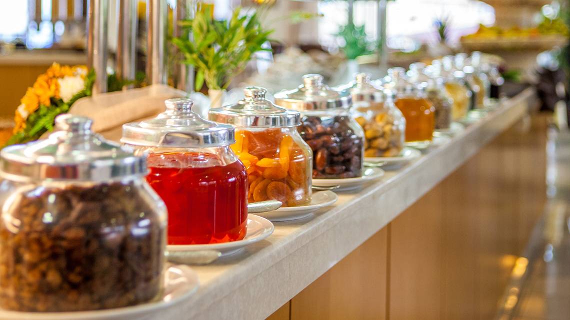 Buffet mit verschiedenen Snacks im Horizon Beach Resort, darunter Aprikosen und getrocknete Früchte in Gläsern.