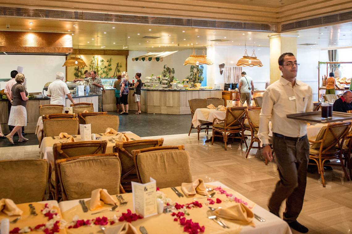 Innenansicht des Restaurants im Siva Grand Beach Hotel mit Gästen und serviertem Essen.